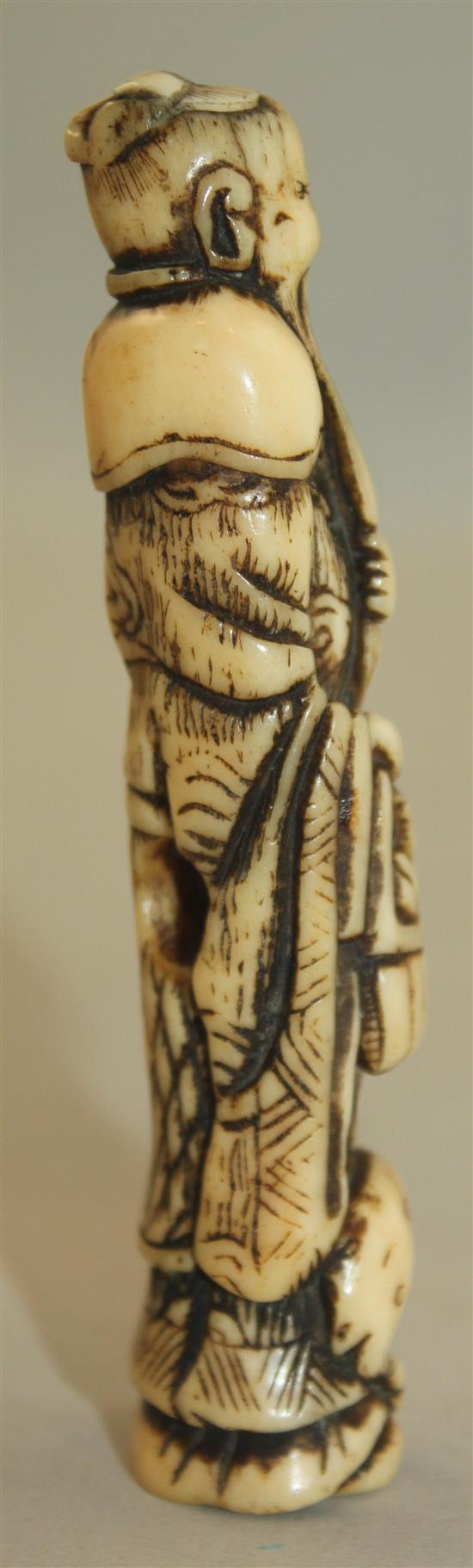 A Japanese stag antler netsuke of a standing sennin, Edo period, 9.8cm